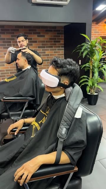 Cliente con gafas de realidad virtual mientras le cortan el cabello